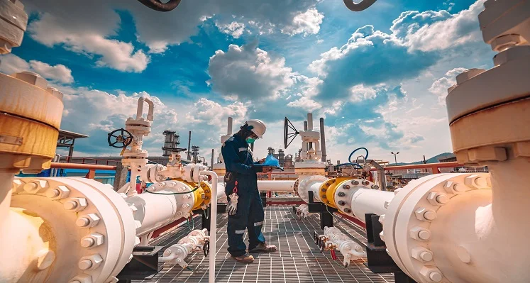 worker inspecting oil and gas setup
