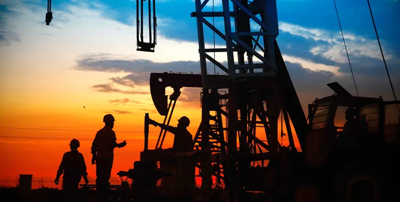 silhouette of oil and gas workers tackling a rig 